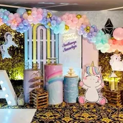 This unicorn party setup for Aaradhya and Ananya uses a vibrant pastel color palette. I included multiple unicorn character cutouts, a large light-up initial 'A', and decorative plinths to create a playful and dynamic stage for the celebration.