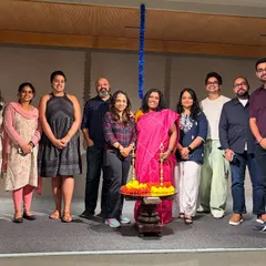 A group of event organizers and speakers smiling for a photo on stage, marking a successful launch.