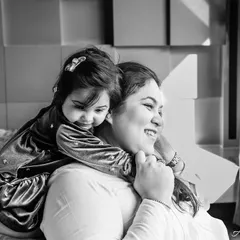 A tender black and white moment between a mother and her child. The hug from behind and their happy smiles create a timeless portrait of maternal love.