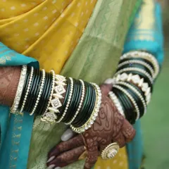 This bride looks stunning in a traditional Maharashtrian gold-finish jewellery set, perfectly complementing her purple and blue nauvari saree.
