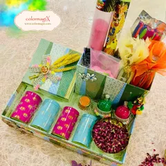 A beautifully arranged Holi hamper featuring colorful jars, organic gulal, pichkaris, and a tray of dried rose petals. It's a luxurious take on traditional Holi gifting.