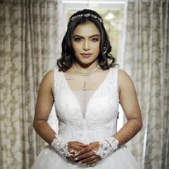 A serene and elegant portrait of the bride in her beautiful white wedding gown. Her calm demeanor and the classic style of her dress and tiara create a timeless and beautiful image.