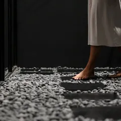 We believe the customer's journey is a tactile one. The use of rough pebble stone flooring is a deliberate choice to slow the visitor's pace, encouraging a mindful, deliberate traversal of the space and a heightened awareness of the physical environment.