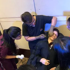 Teaching is most effective when it's interactive. Here, I'm guiding a group of dermatologists through the intricacies of filler application, ensuring every question is answered and every technique is understood.