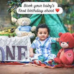 This image is an invitation to book a first birthday shoot, showcasing a happy one-year-old in a camp-themed setup, complete with teddy bears and a "ONE" sign.
