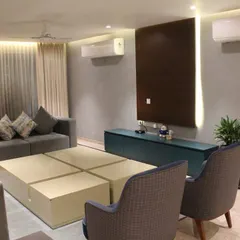 The living room from our Hyderabad project, featuring several of our custom pieces. This includes the low-profile TV console, the large modular coffee table, and the grey sofa.