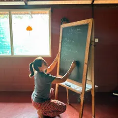 A student writes Sanskrit terms on the blackboard. Learning the language of yoga is a way of honoring its roots and understanding the deeper meaning behind the words we use in class.