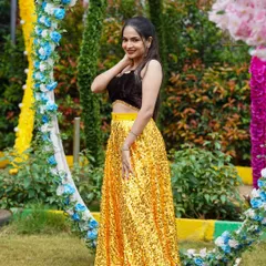 A full shot from a fashion shoot, this look is designed to be eye catching. The makeup is clean and bright, complementing the sparkling yellow skirt and dark top for a balanced, camera ready appearance.
