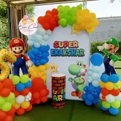 Bringing the game to life with a Super Mario themed birthday party. This outdoor setup includes character cutouts of Mario and Luigi, a custom backdrop, and vibrant balloon columns.