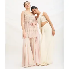 Light, fluid, and made to move with you. This image showcases two beautiful options for daytime celebrations: a pastel pre-draped saree and an effortless sharara set. Both are perfect for wedding guests who value comfort and style.