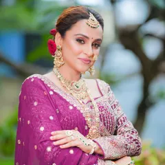 A confident pose showcasing the full bridal attire. The makeup enhances her features without overpowering her natural beauty.