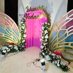 A view of the butterfly wings during setup, showing the intricate floral arrangements and the gold detailing on the wings. Each piece is constructed to be a standout feature.