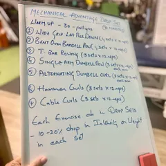 This is an example of a "Mechanical Advantage Drop Set" workout plan we design for clients. It details specific exercises like pull-downs and rows, showcasing the scientific and structured nature of our strength programs.
