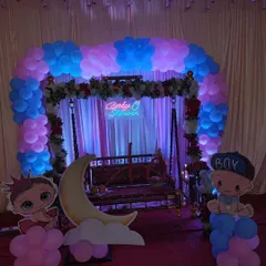 A classic setup for a Dohale Jevan or baby shower, featuring a decorated swing (jhula) under a beautiful balloon arch. This blends modern decor with traditional elements.