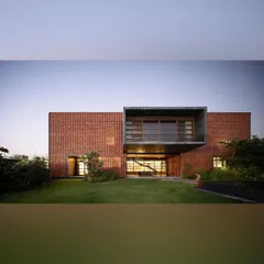The rear view of the Ishtika house opens onto a manicured lawn. The design features a dramatic cantilevered box, and our landscape plan provides an open, green expanse that complements the home's strong architectural forms.