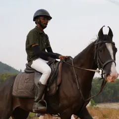 A rider on a handsome black horse during a safari, enjoying the natural scenery. Our horses are suited for all types of terrain.