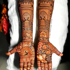 A beautiful example of symmetrical design work, featuring peacocks on the palms and forearms. The top of the arms is crowned with architectural domes, giving it a royal feel.