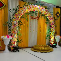A closer look at the Haldi stage, highlighting the dense floral arch made of marigolds and roses, with hanging floral strings for a traditional touch.