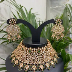 This intricately designed Kundan choker set features floral motifs and green stone accents. Rent this for a sangeet or mehendi ceremony to add a touch of tradition.