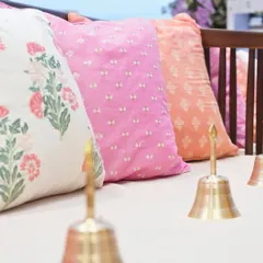 A close-up of the seating arrangement, featuring custom-printed cushions and traditional Indian bells. We blend textures and patterns to create a layered and visually rich experience.