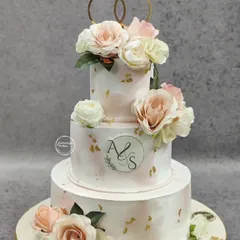 A beautiful three-tiered vintage wedding cake for a special couple. The soft pink marble effect, delicate gold leaf flakes, and fresh roses create a romantic and timeless look. The custom monogram adds a personal touch to this engagement cake.