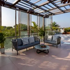 Another view of the Faridabad terrace, highlighting the comfortable, weather-resistant rope furniture and striped cushions that create an inviting space for conversation. The design ensures the city view remains unobstructed.