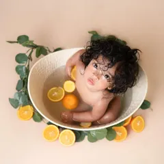 A beautiful overhead shot of our fruit bath session. This little one with the gorgeous curls looks so serene and curious surrounded by oranges in the water.