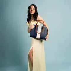 A full-length shot from the Lavie campaign. The model holds the handbag in a way that shows its size and shape, providing important visual information for a potential customer.