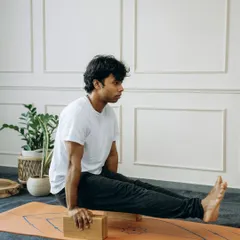 A yoga block can be a bridge to new levels of strength. Here, a student uses blocks to practice L-sit (Brahmacharyasana), building the core and arm strength necessary for more advanced arm balances.