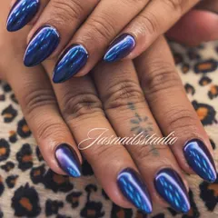 A close-up of the stunning blue chrome nails. The way the light hits the surface and creates different shades of blue and purple is just mesmerizing. This is a true statement nail.