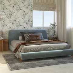 A minimalist bedroom design where simplicity meets class. The soft blue upholstered bed is set against a delicate, nature-inspired wallpaper, creating a light and airy feel.