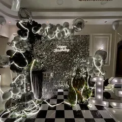 A different angle of the disco party setup, highlighting the layered details like the LED light strips woven through the balloons and the reflective disco balls that catch the light.