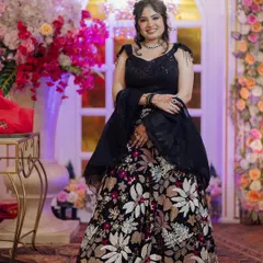 A happy client in the black floral rental lehenga. The combination of a dark base with colorful floral work makes it a unique and memorable outfit.