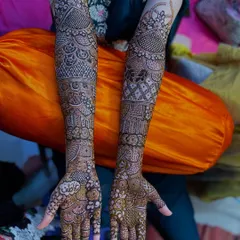 A full view of a bridal henna design, featuring the name "Adil" written on the palm.