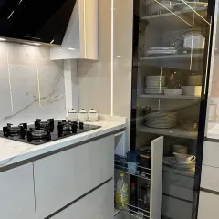 This close-up reveals a narrow pull-out spice rack, a smart storage solution placed conveniently next to the hob. It keeps cooking oils, sauces, and spices organized and within easy reach.