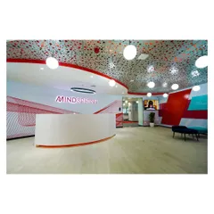 The reception for Mindsprint in Bangalore makes a bold first impression. We used a curved desk, intricate perforated ceiling with globe lighting, and the company's brand colors to create a welcoming yet futuristic entrance that immediately communicates a forward thinking identity.