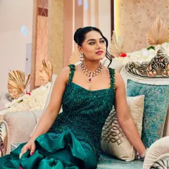 Posing in a beautiful emerald green gown before a reception event. The intricate beadwork and mermaid silhouette make it a real showstopper for an evening of elegance.