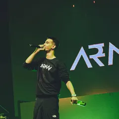 On the mic, commanding the stage during a concert. My performance style involves direct engagement to build energy and connect with everyone in the venue.