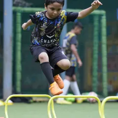 Leaping over hurdles, a young player works on his agility and coordination. These foundational exercises are crucial for developing athletic ability and preventing injuries.