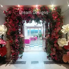 A grand floral entrance I designed for a special event. The arch is overflowing with pink bougainvillea and accented with large, whimsical paper flowers, creating a joyful and dramatic welcome.