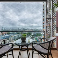 Another perspective of a cozy balcony space. Enclosed in gentle netting, two chairs and a small table create a simple yet inviting spot to relax and embrace the moment.
