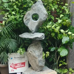 The unique, balancing design of this large abstract sculpture makes it a captivating addition to any landscape. It is hand-carved from natural stone for an authentic, rustic feel.