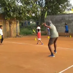 I demonstrate the correct ready position and volley technique to a group of young players. Group sessions ensure students learn from both instruction and observation.