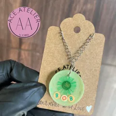 A simple and sweet memorial pendant for a pet named Bob. His hair is preserved in a light green resin circle, a small and personal way to keep his memory alive.