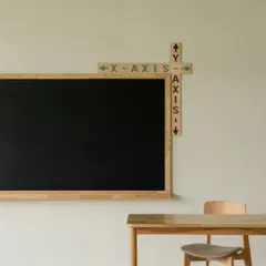 The math lab features a clean, minimalist aesthetic to encourage focus. A simple wooden-framed blackboard is complemented by fun, educational graphics for the X and Y axes.