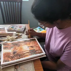 Here is my offline student Harshni, carefully adding details to her watercolour landscape. She is learning to layer colours to create depth and light.