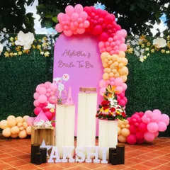 A bright and cheerful "Bride to be" party decor. The pink and peach balloon arch against a green wall creates a perfect photo booth area for the bride and her friends.