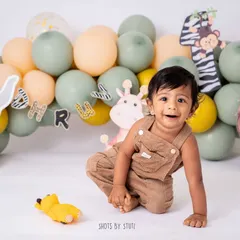 A jungle-themed cake smash is a perfect way to celebrate a "wild one." This little cub is having a great time exploring his setup before digging into the cake.