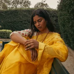 A quiet, contemplative moment on the bench, showcasing the soft drape of the saree. I use different poses and moods to bring out the subject's personality during a portrait session.