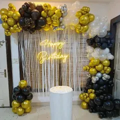 A stylish half-arch in black, gold, and white, complete with a neon sign and a shimmer curtain. This setup instantly creates a festive photo corner.